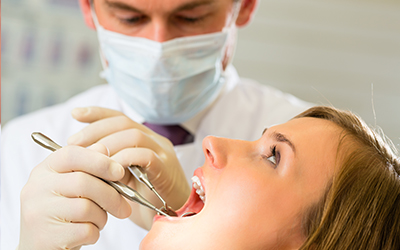 A female patient with a male dentist working on her teeth