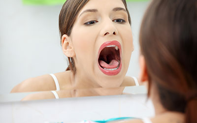 Woman checking her mouth out in mirror