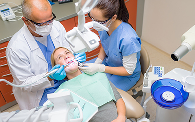 A patient sitting in a dental chair having her teeth worked on