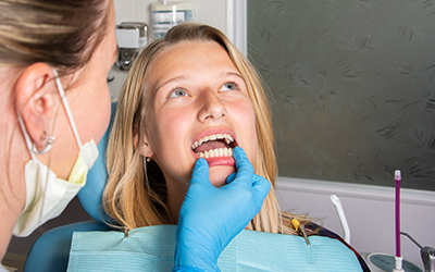 A dentist looking at a womans teeth