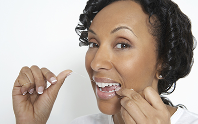 A woman flossing her teeth