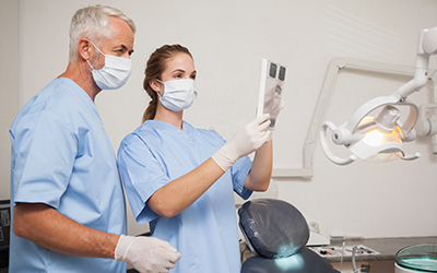 Dentist and assistant studying x-rays