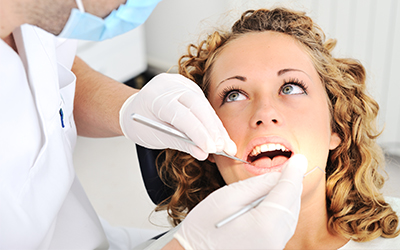 An upclose picture of a dentist working in a womans mouth