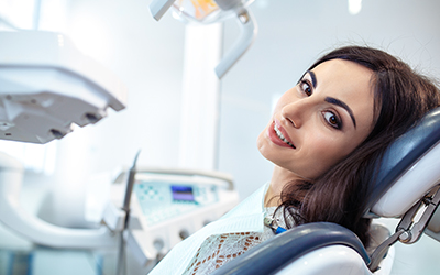 A woman sitting in a dental chair ready for a procedure