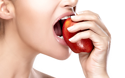 A woman biting into an apple