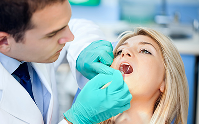 A dentist looking into the mouth of a patient