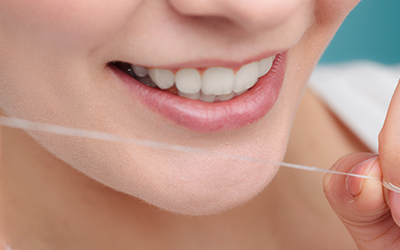 Woman smiling with dental floss